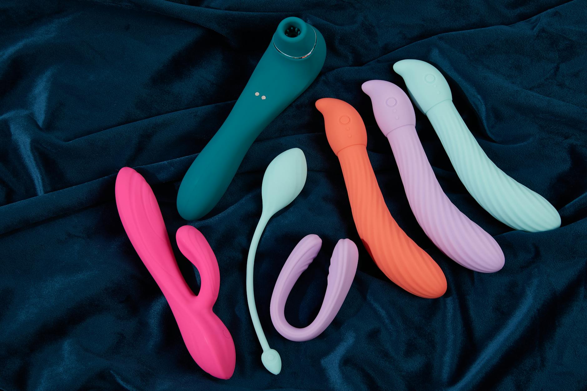 Hand holding a basket of colorful clitoral vibrators and flowers